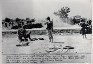 Marines Blast Enemy: U.S. marines in foreground guard ears as their artillery shells enemy concentrations in the hills surrounding their position somewhere on the Korean front, August 10
