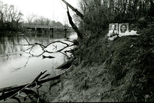 Portraits of the two victims found near the river, with flowers, portraits, and candles along the Chattahoochee River (light), Atlanta, Georgia