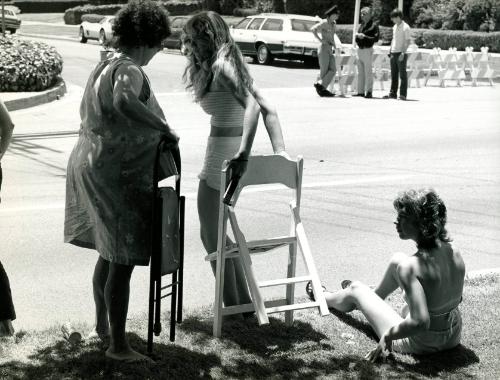 Women with folding chairs on curb