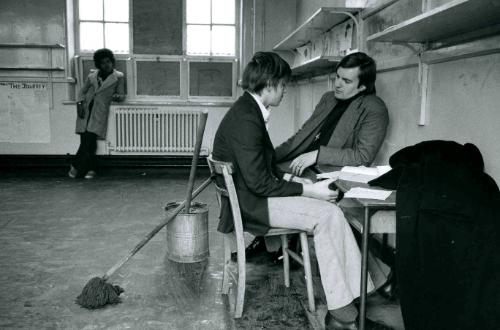 A teacher talks with a young boy about his education at a special school for truants, England