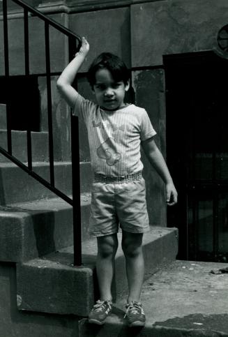 Boy holding railing, New York City